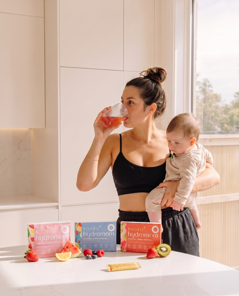 Mom drinking Hydromom while holding baby